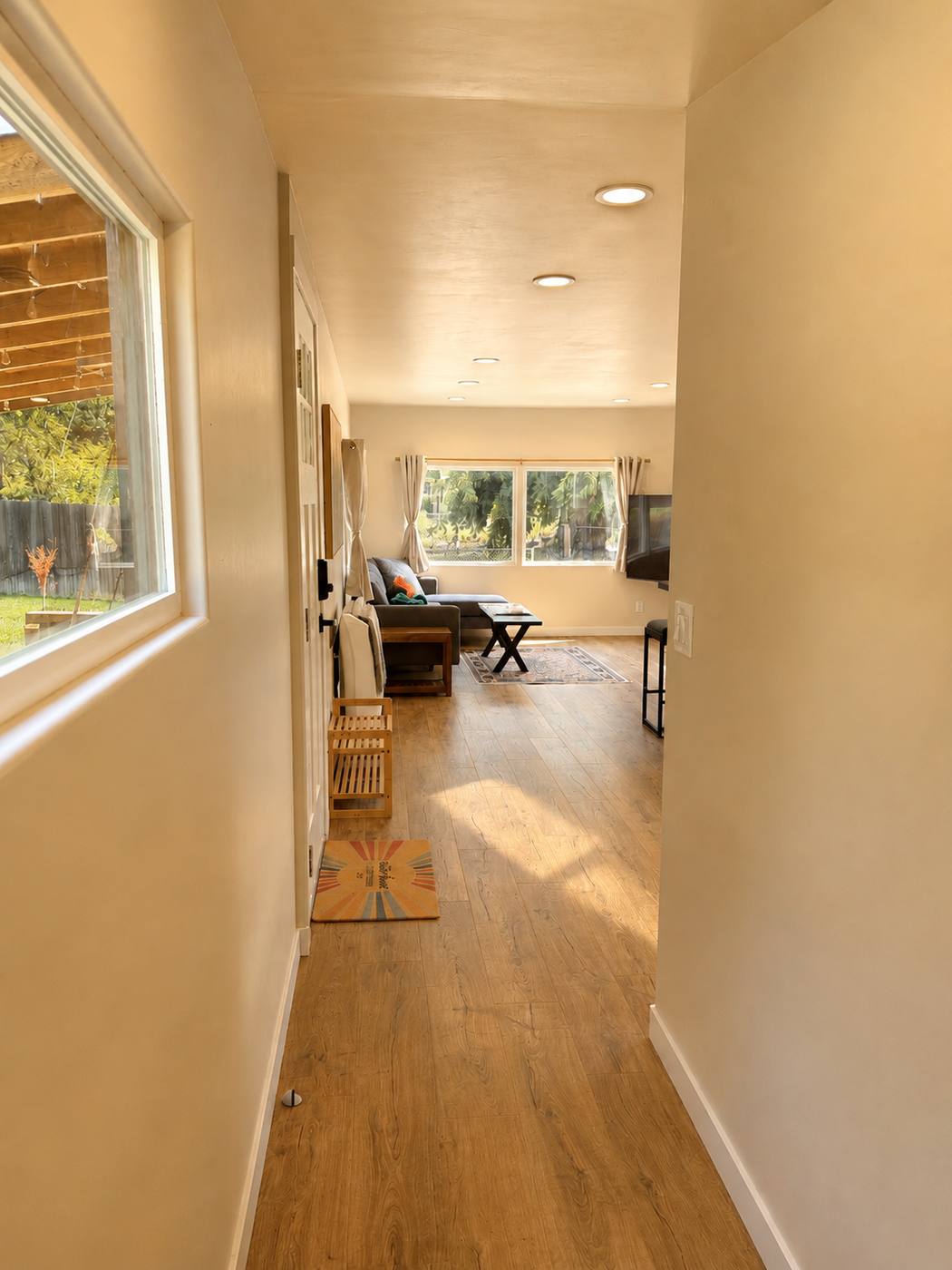 Entry hallway with a window onto the deck, looking through to the living room