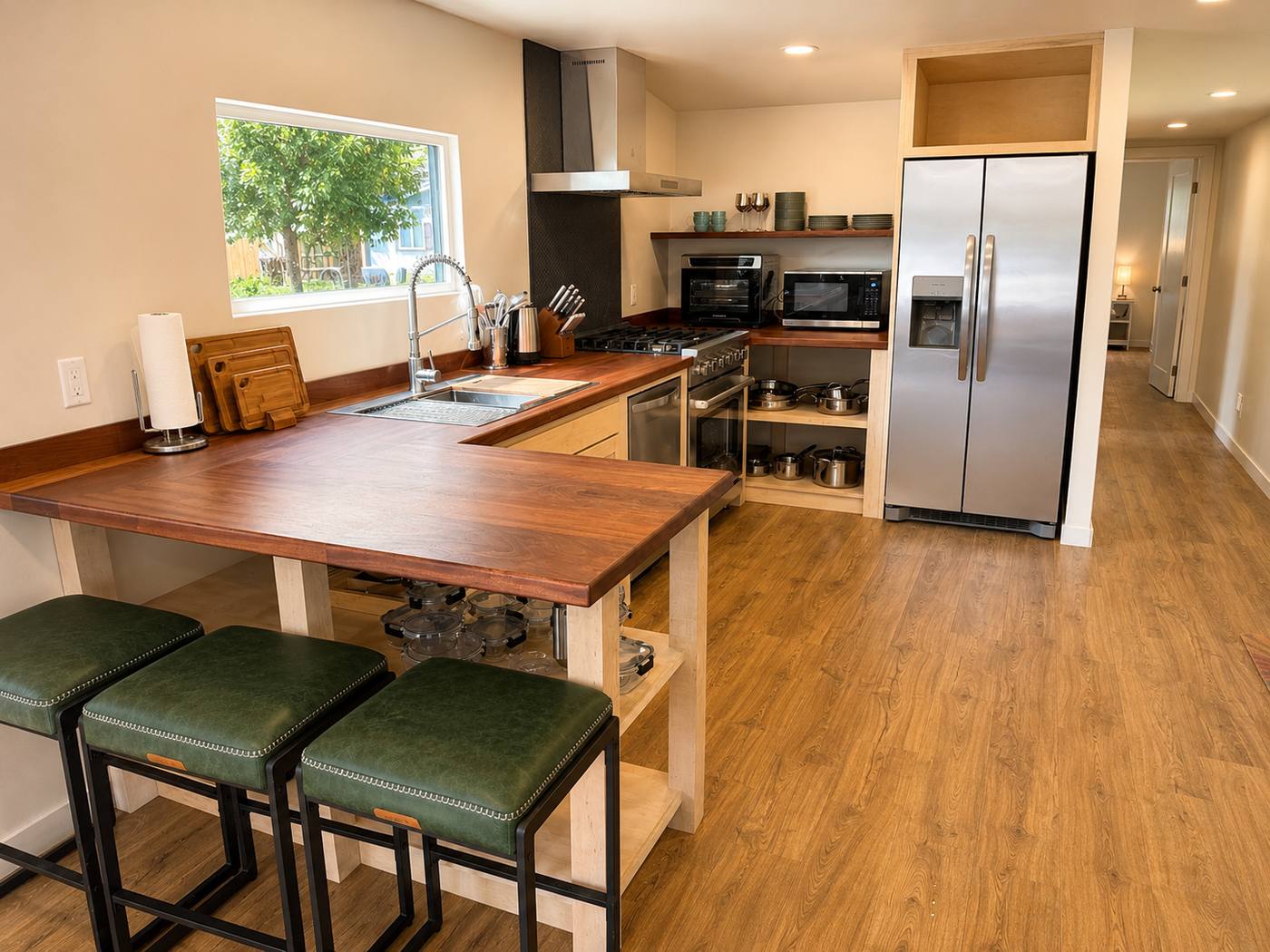 Kitchen with walnut counters, U-shaped bar seating three, stainless range and side-by-side refrigerator