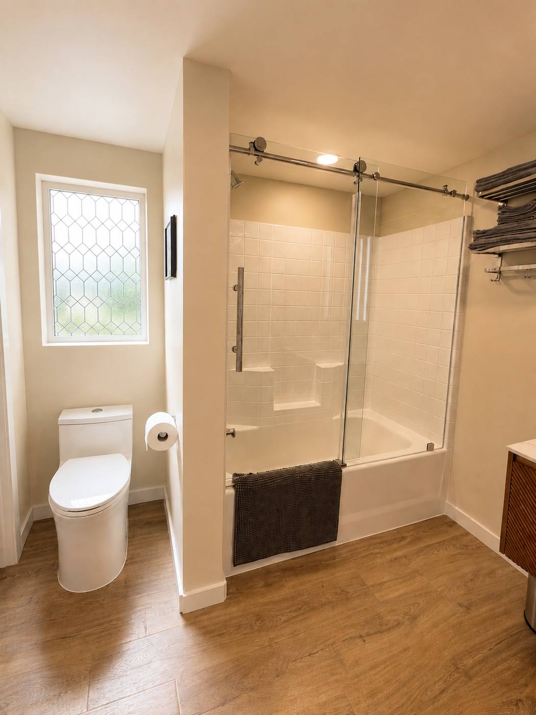 Bathroom from the doorway, showing the shower over tub, obscured-glass window and toilet