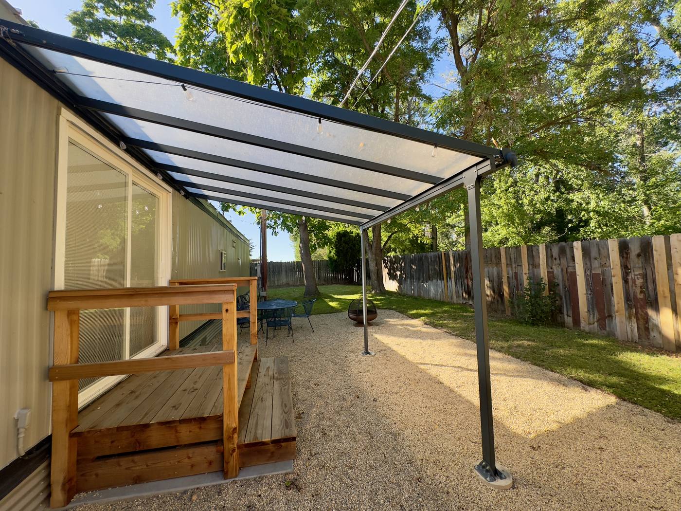 Under the patio awning looking out to the gravel terrace and fire pit